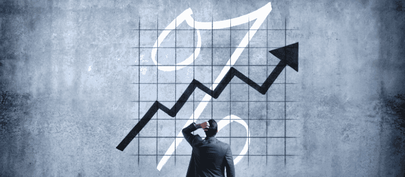 Man kijkt naar een stijgende zwarte lijn met percentage-symbool op een getekend raster.