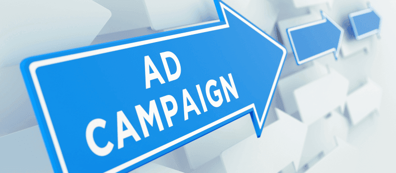 Blauwe pijl met de tekst "Ad Campaign" tegen een wazige achtergrond met andere pijlen.