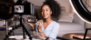 Vrouw demonstreert make-uptechnieken tijdens het opnemen van een video voor haar beauty vlog.