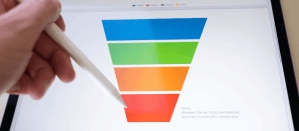 Hand met stylus wijst naar een digitale kleurrijke verkooptrechter op een scherm.