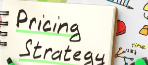 Notitieboek met de tekst 'Pricing Strategy' onderstreept in groen, omringd door kleurrijke schetsen.