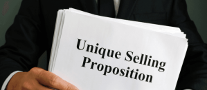 Man in pak houdt een document vast met de tekst Unique Selling Proposition.