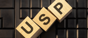 Houten blokken met de letters USP op een toetsenbordachtergrond, concept uniek verkoopargument.