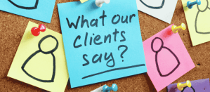 Blauwe post-it met de tekst "What our clients say?" op een prikbord met gekleurde notities.