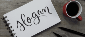 Handgeschreven slogan in notitieboek met koffie en pennen op houten tafel.