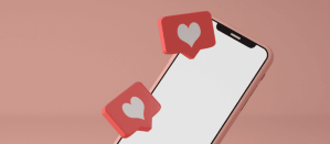 Roze smartphone met zwevende social media like-iconen op roze achtergrond.