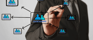 Man in pak tekent een social network schema met pijlen en icoontjes.