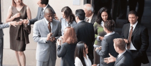 Professionals in gesprek en visitekaartjes uitwisselend tijdens een netwerkbijeenkomst.