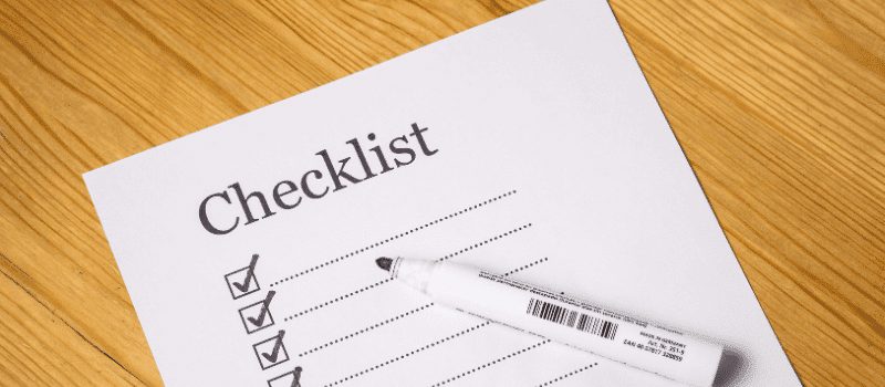 Papieren SEO checklist met vinkjes en zwarte marker op houten tafel